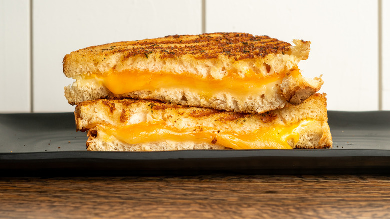 A grilled cheese sandwich with gooey cheese and slightly burnt bread for a crispy and delightful flavor