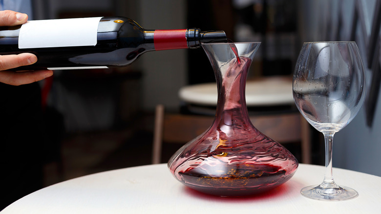 Red wine being poured into a decanter