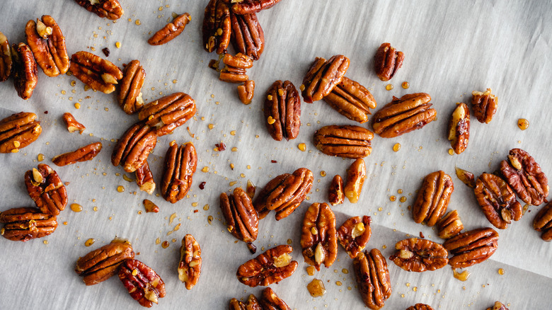 candied pecans scattered on a grey surface
