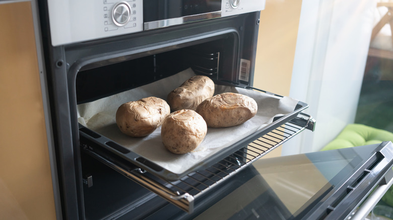 Baked potatoes sit on an oven rack