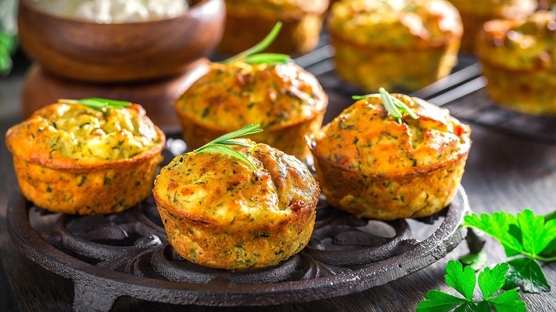 Four zucchini muffins on a cast-iron trivet