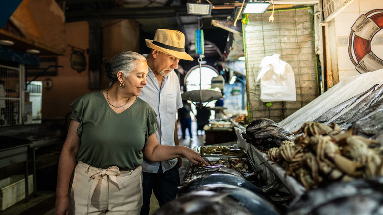 Customers shopping for fresh fish at a market