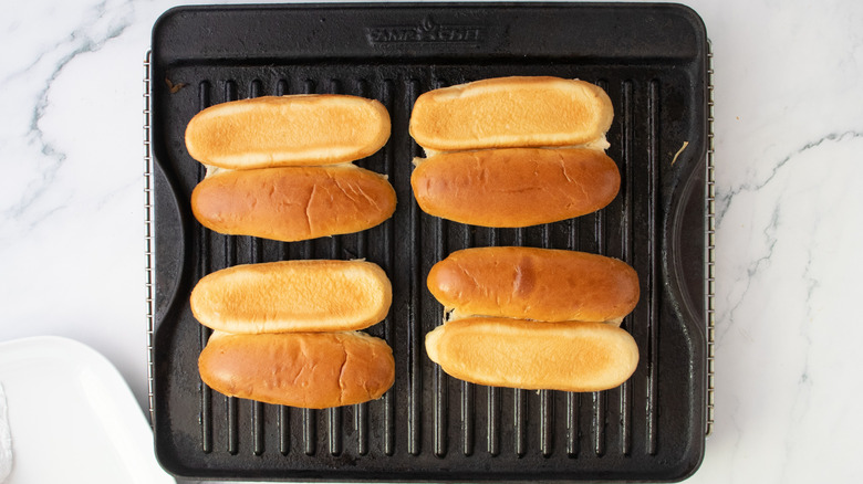 Buttered buns on a large grill pan
