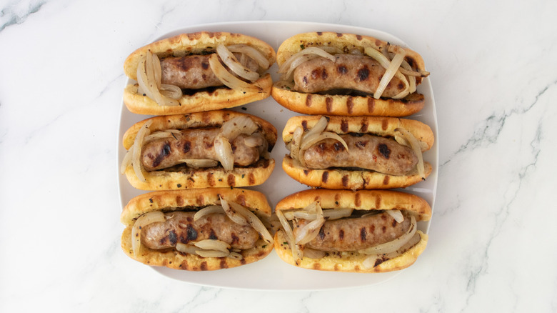 Grilled buns filled with brats and onions