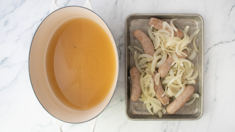 Cooked brats and onion removed from pot and placed on a baking sheet