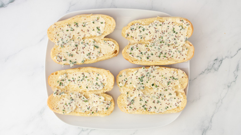 Hot dog buns spread with compound butter