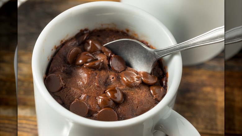 Spoon in a mug brownie topped with chocolate chips