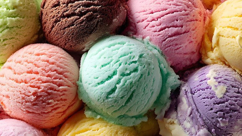 A closeup of scoops of ice cream in a variety of flavors