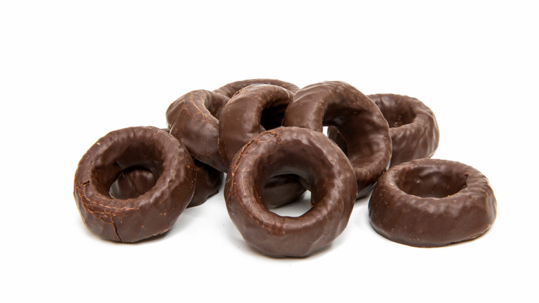 A bunch of chocolate rings on a white background.