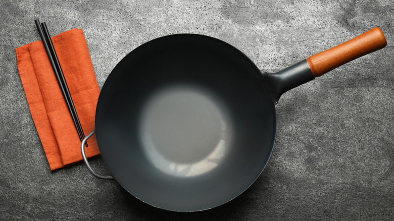 an empty iron wok and chopsticks