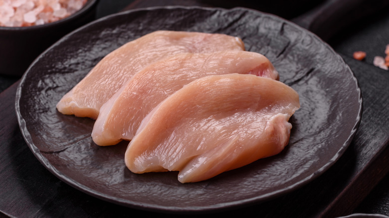 Uncooked chicken breasts on a plate