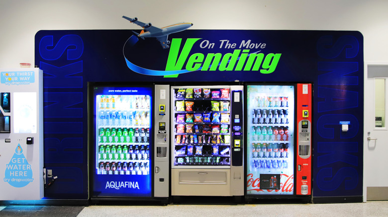 Several vending machines containing drinks and snacks lined up next to each other in a Kentucky airport