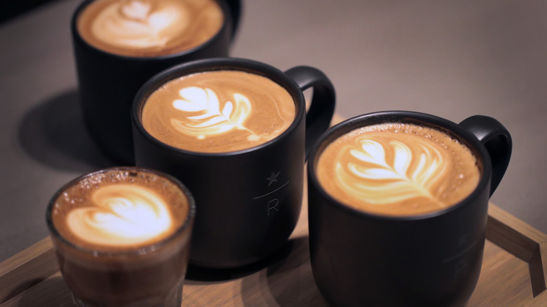 Four hot coffee lattes complete with foam designs