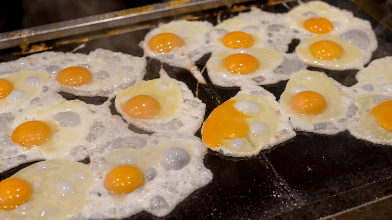 eggs frying on a griddle
