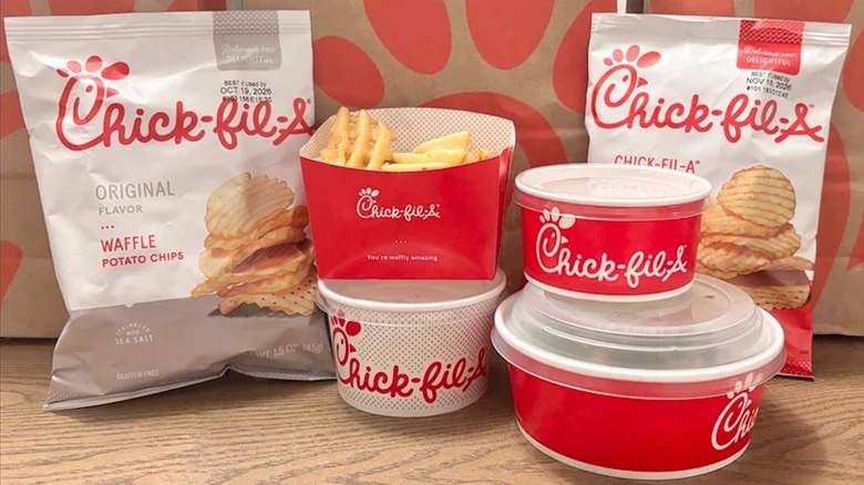 A variety of side dishes offered by Chick-fil-A sit on wood countertop