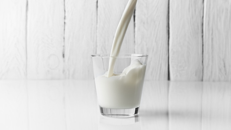 Glass of milk on white surface