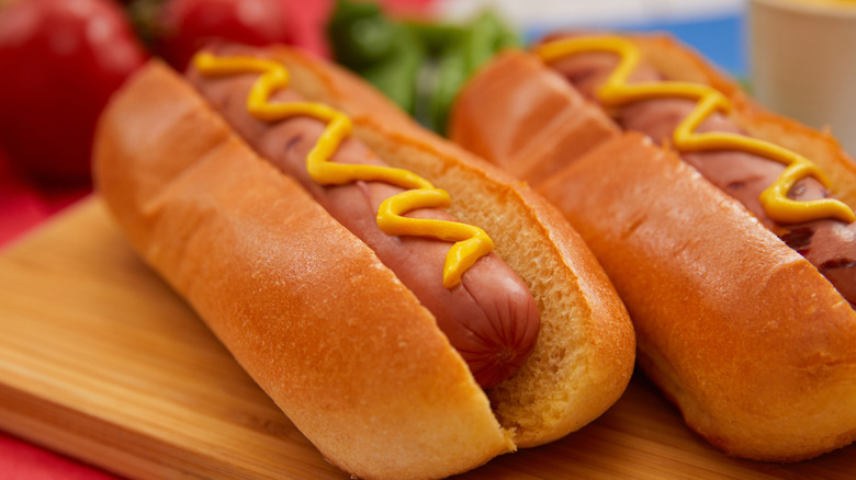 hot dogs in buns with a drizzle of mustard