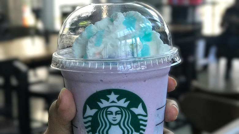 From the Starbucks Secret Menu, a frozen, purple drink topped with whipped cream drizzled in blue syrup