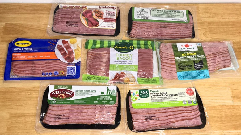 An array of different turkey bacon packages lined up next to each other.