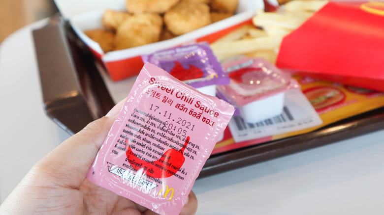 person holding sauce container