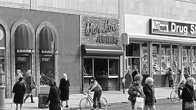 Black and white photo people in front of various stores, including a Pathmark drug store