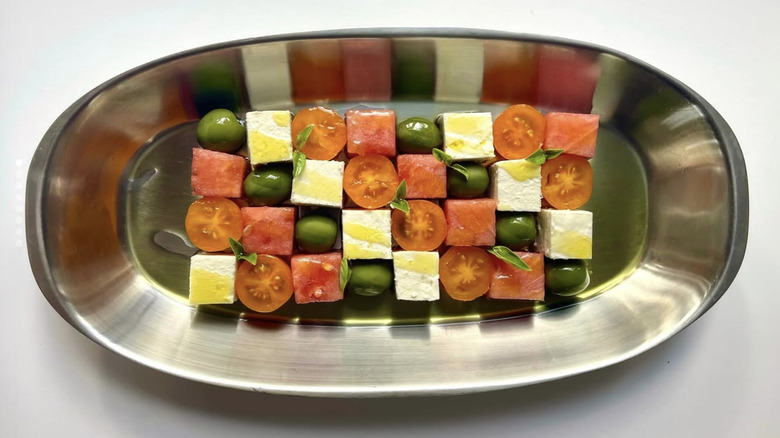 tomatoes, feta, green olives, melon checkerboard on metal platter