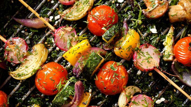 seasoned vegetable on skewers resting on grill