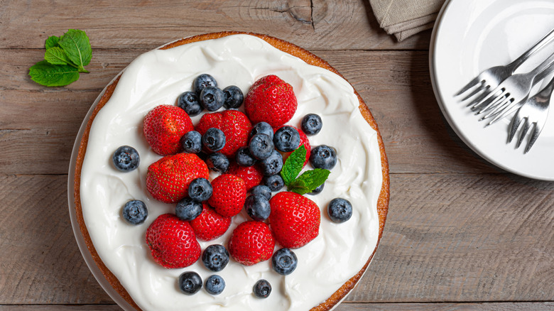 Simple cake iced with whipped cream and berries
