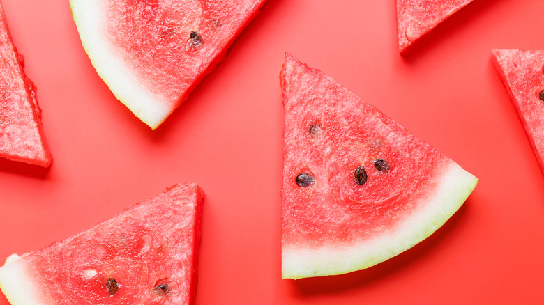 Juicy watermelon slices on a red background.