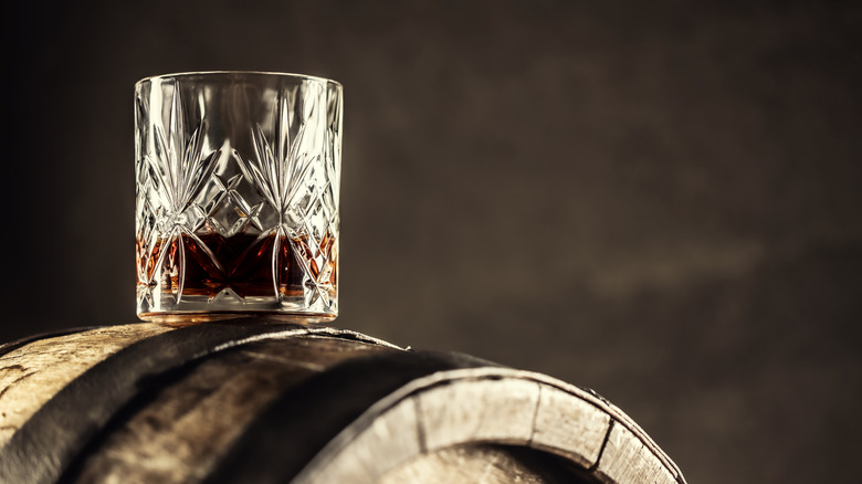 Glass of whiskey on barrel