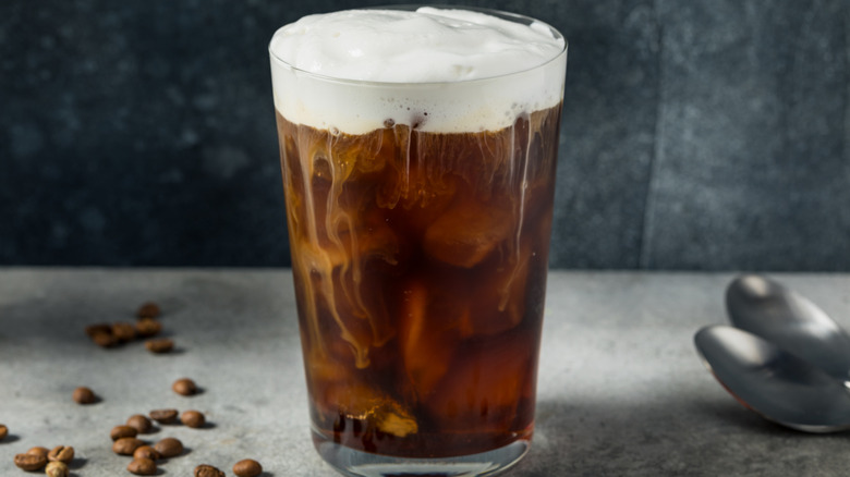 Glass of iced coffee with cold foam on top