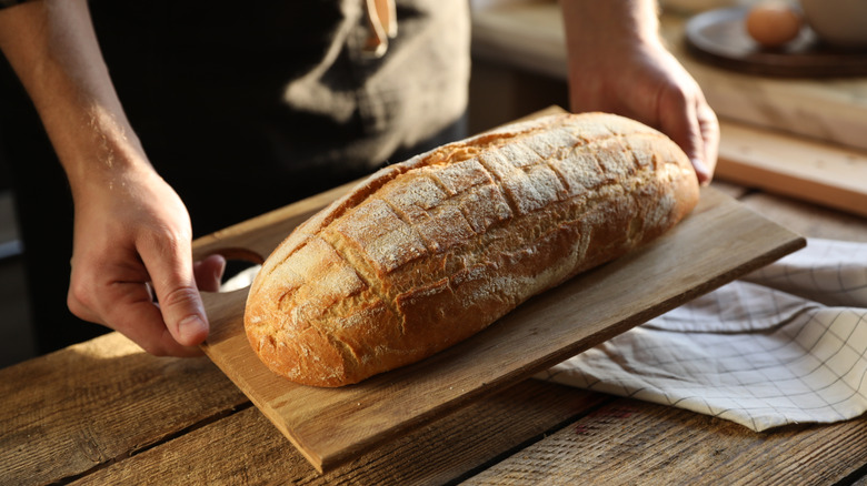 Man holding a loaf of freshly baked bread