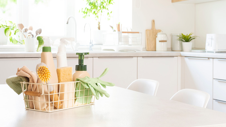 A clean kitchen with soap, scrubbers and rags in a crate