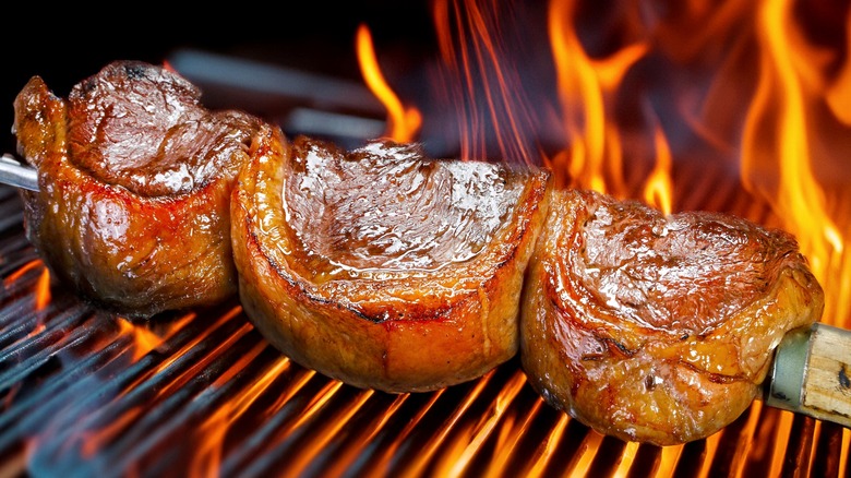 picanha steaks being cooked on a rotisserie grill