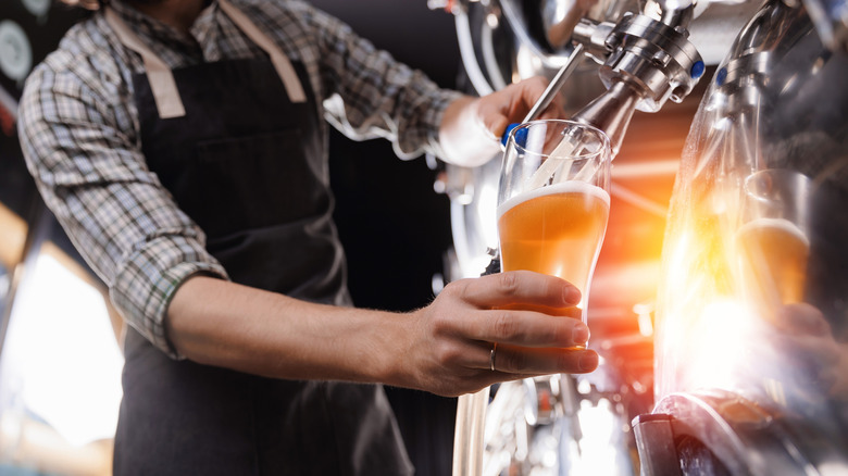 Brewer pouring beer in glass