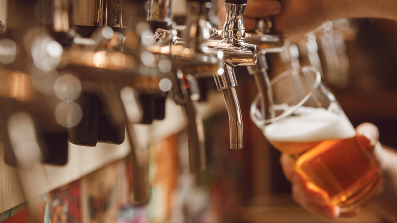 Bartender filling a glass from a tap