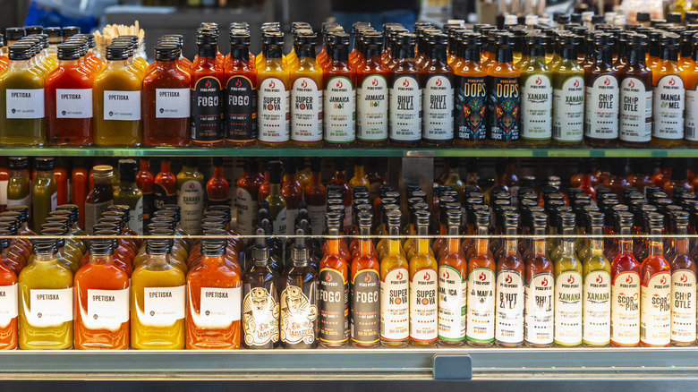 Cases of hot sauces on a store shelf