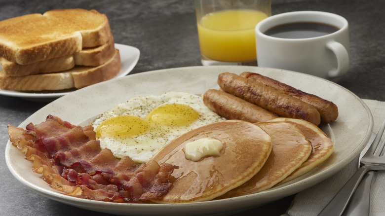 Diner breakfast on a plate with coffee and juice.