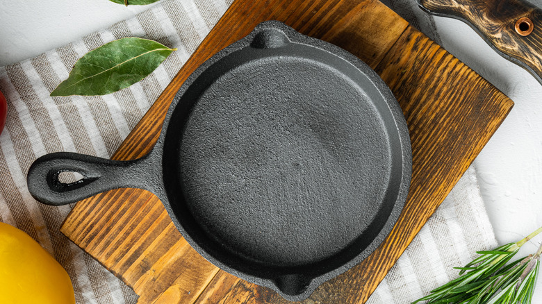 Freshly seasoned cast iron pan on a wooden cutting board