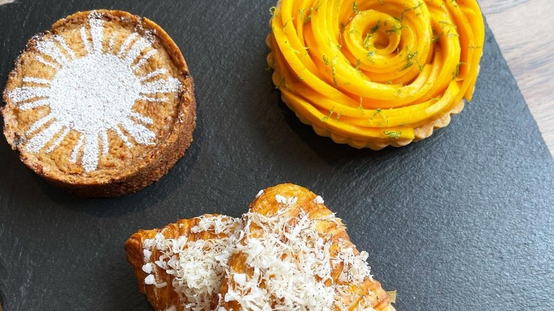 Assorted pastries from Kasama, including an ube an huckleberry basque cake, mango tart, and truffle croissant