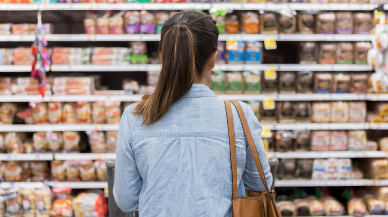 A person looking at the bread aisle in a grocery store