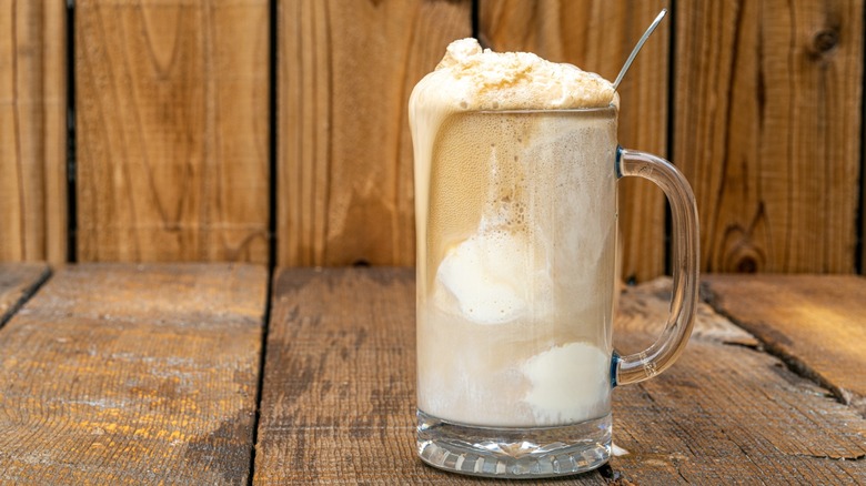 A root beer float on a wooden deck