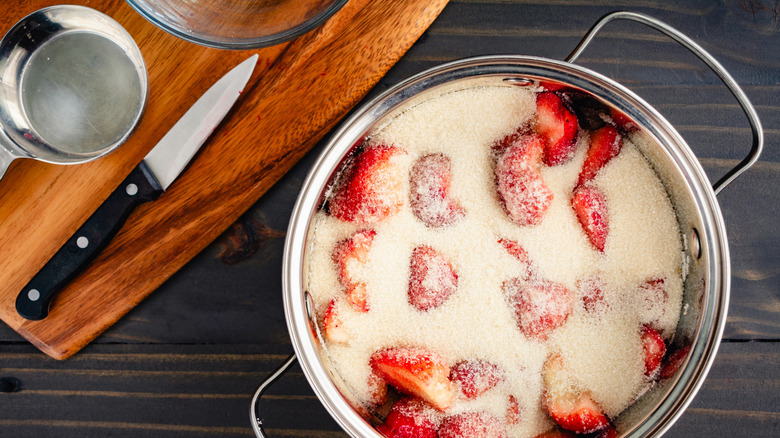 saucepan full of fresh strawberries covered in sugar