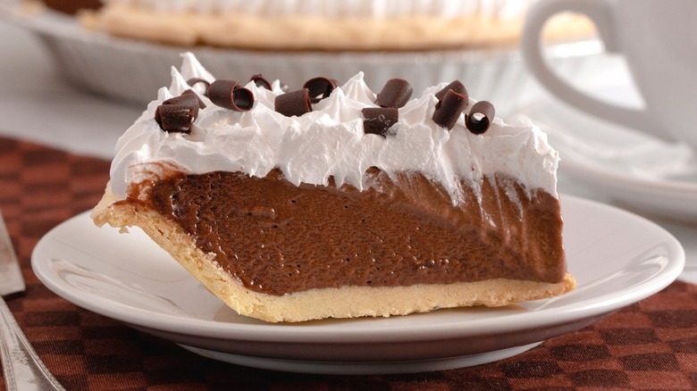 Slice of chocolate icebox pie topped with whipped cream and chocolate pieces