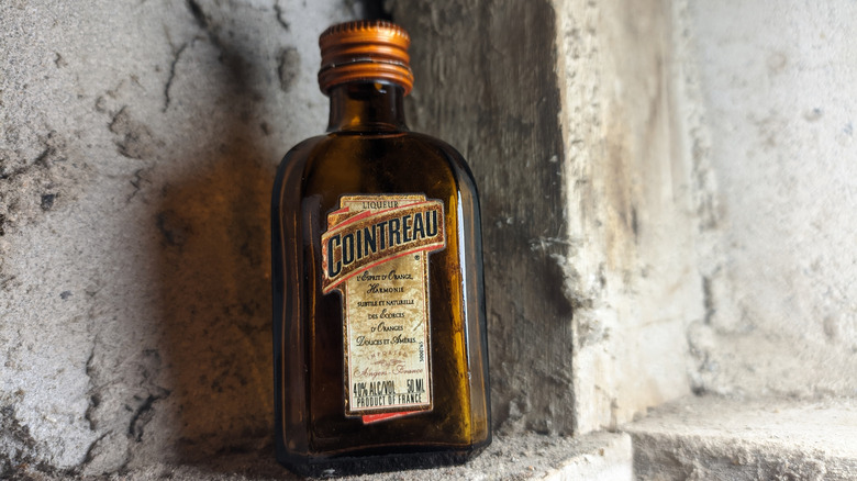 A Cointreau bottle rests against a wall