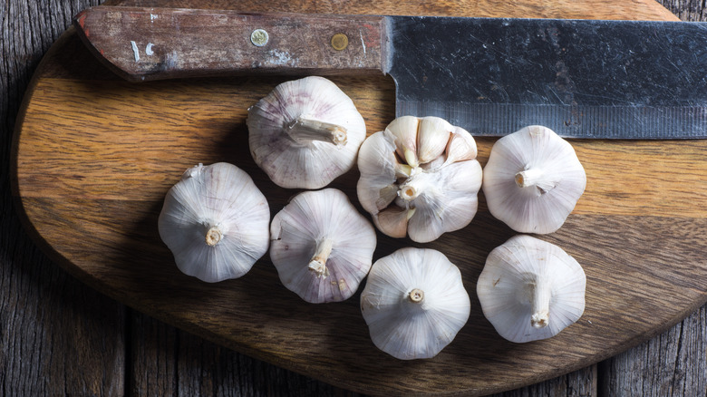 Whole garlic bulbs on wood cutting board