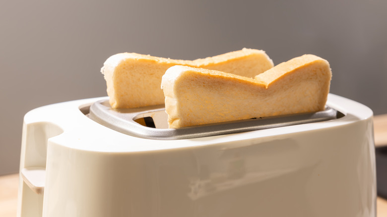 toast sticking out of the top of a white toaster
