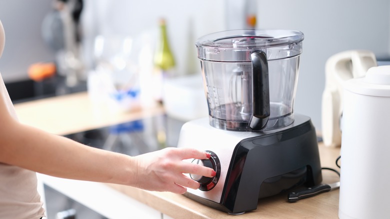 woman turning on empty food processor