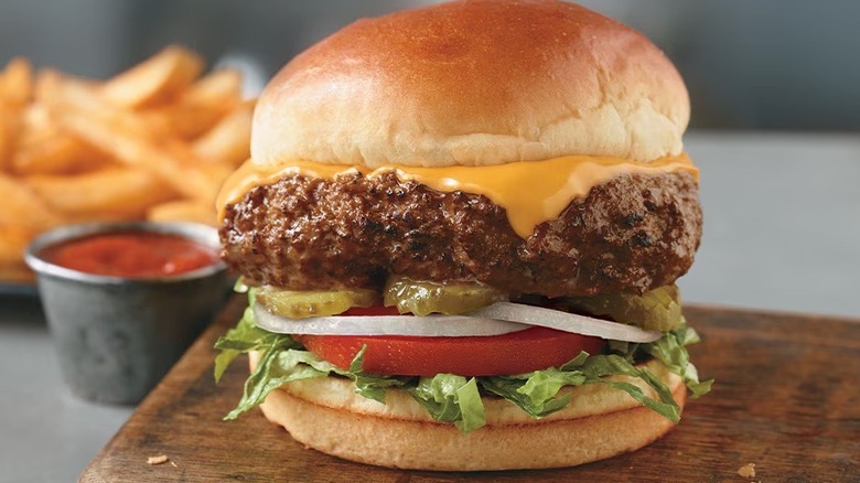 Longhorn Steakhouse's half pound cheeseburger sitting atop a wooden cutting board