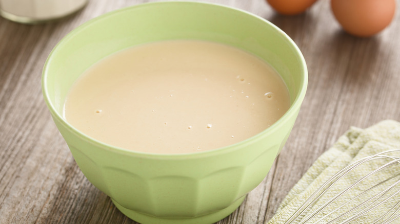 Green kitchen bowl filled with batter
